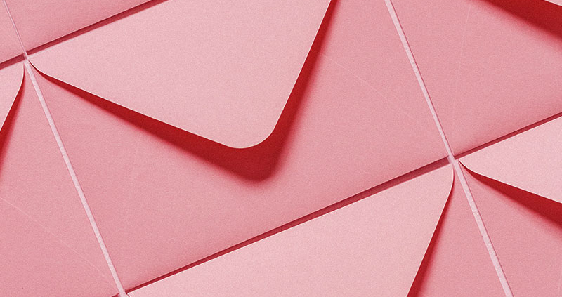 Multiple pink envelopes laid out side by side