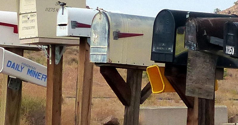 Mailboxes of various size, shape, and color in a long row